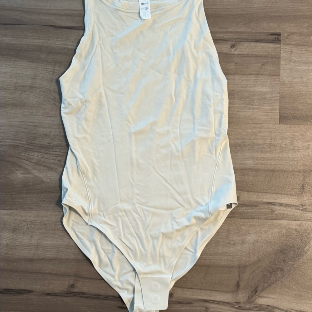 NWT. Cream Lululemon Body Suit. Size M.